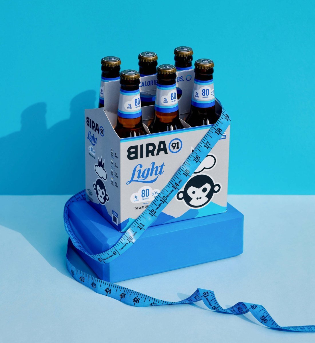 Bira 91 Light six-pack with measuring tape on blue