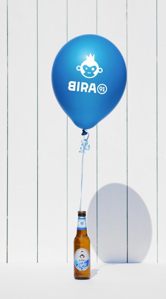Bira 91 Light bottle floating on a blue brand balloon
