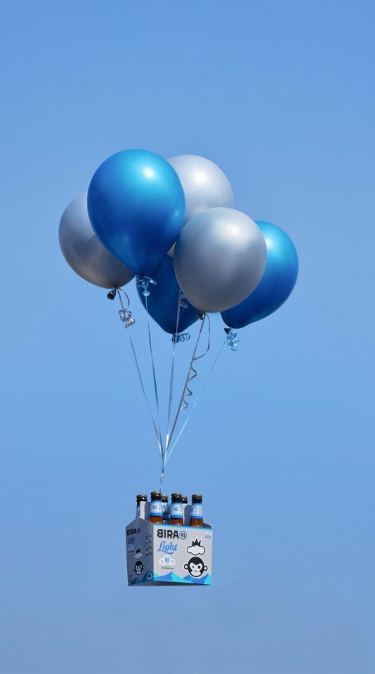 Bira 91 Light six-pack carried by a cluster of balloons