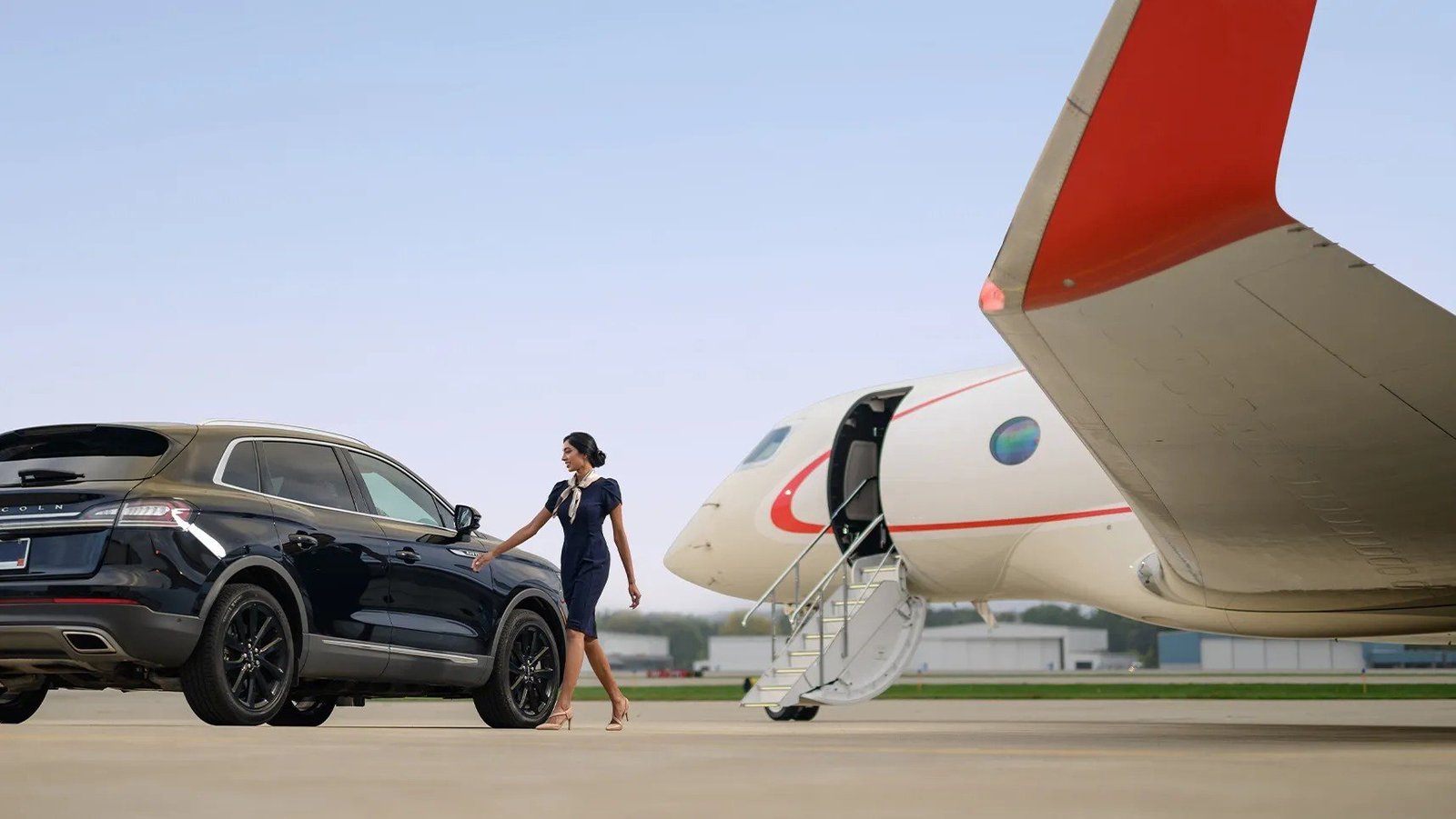 Pentastar flight attendant greeting arriving client at jet